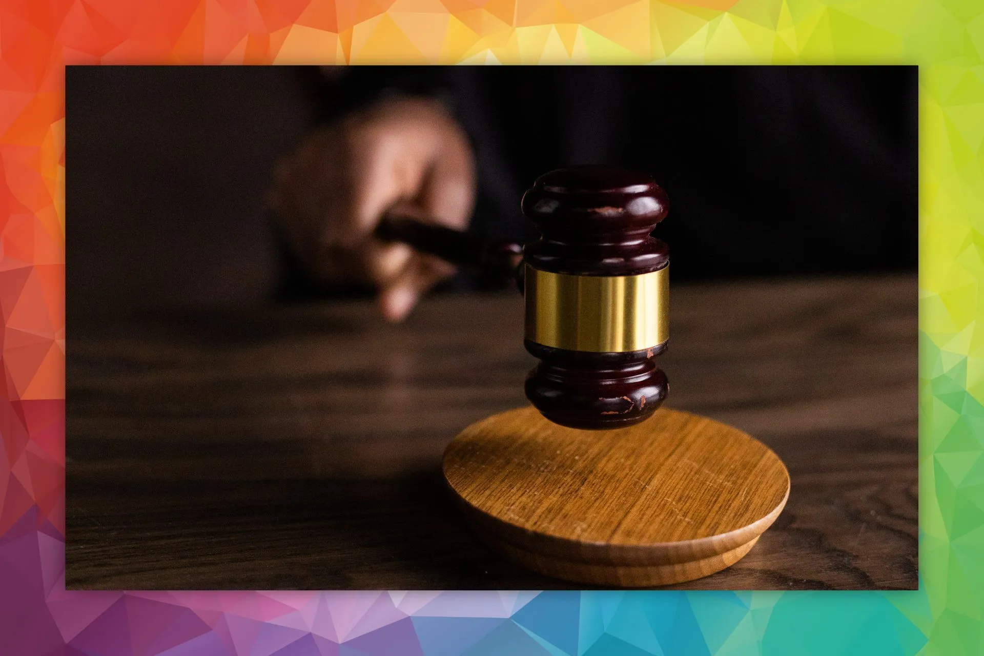Close-up of a gavel on a table with a colorful background.